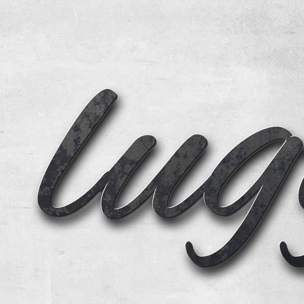 Schriftzug "luggage >" in Schriftart "Jessari", Cortenstahl unbehandelt - hochwertig & wetterbeständ