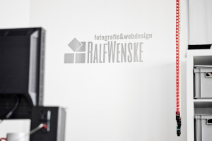 Edelstahl-Logo auf Wand aufgeklebt