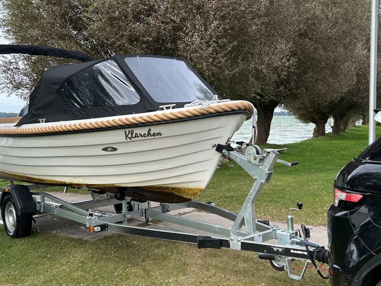 Schriftzug Sunside aus gebürstetem Edelstahl an der weißen Außenwand eines Bootes