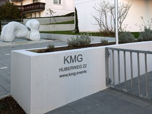 Firmenlogo aus gebürstetem Edelstahl auf Sichtbeton