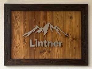Firmenlogo aus gebürstetem Edelstahl mit Holzrahmen