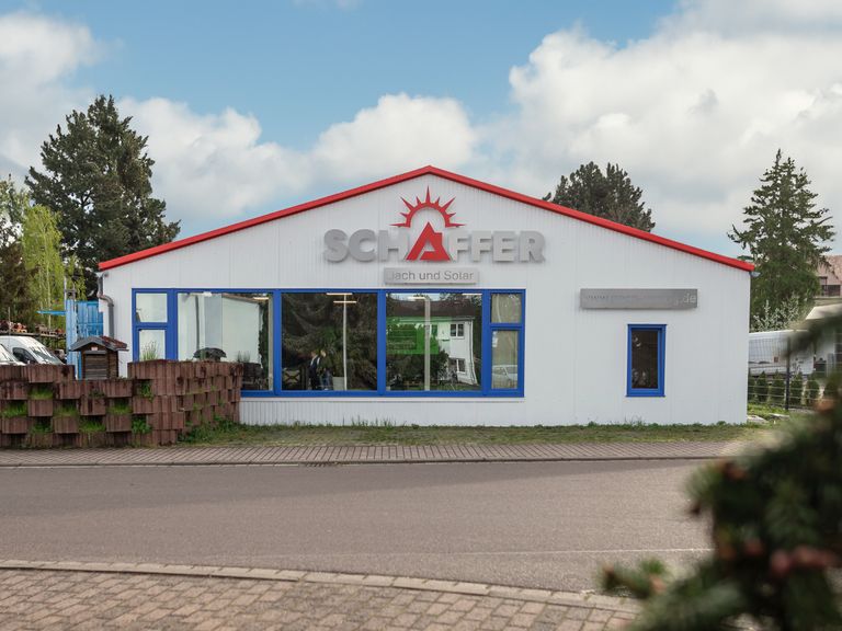 SIGNOSTAR Logo aus Edelstahl mit roter Pulverbeschichtung an Firmenfassade