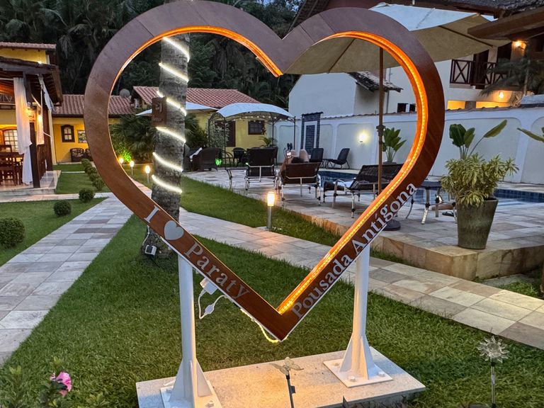 Beleuchtetes Herz mit dem Schriftzug I Love Paraty Pousada Antígona in einer Hotelanlage