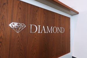 Polierte Edelstahlbuchstaben auf Holzoberfläche