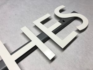 Pulverbeschichtung von Metallbuchstaben und Firmenlogos